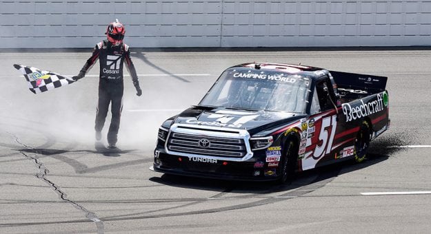 Kyle Busch fetches the checkered flag after winning the Truck Series race at Pocono.