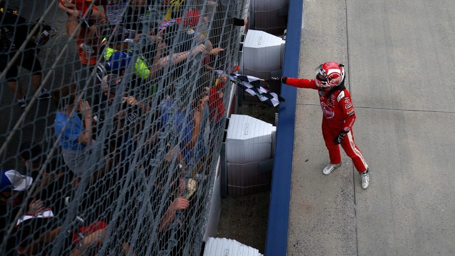 DOVER, DE - OCTOBER 06: Christopher Bell, driver of the #20 Rheem Toyota, hands the checkered flag to a fan after winning the NASCAR Xfinity Series Bar Harbor 200 presented by Sea Watch International at Dover International Speedway on October 6, 2018 in Dover, Delaware. (Photo by Chris Trotman/Getty Images) | Getty Images