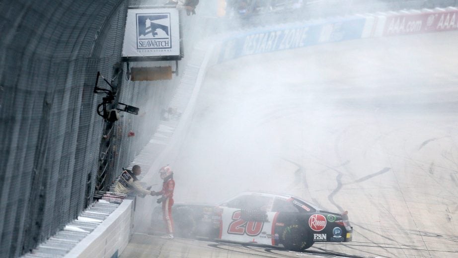 DOVER, DE - OCTOBER 06: Christopher Bell, driver of the #20 Rheem Toyota, grabs the checkered flag from a NASCAR official after winning the NASCAR Xfinity Series Bar Harbor 200 presented by Sea Watch International at Dover International Speedway on October 6, 2018 in Dover, Delaware. (Photo by Jonathan Ferrey/Getty Images) | Getty Images