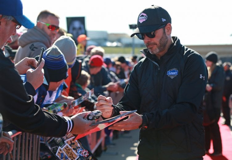KANSAS CITY, KS - OCTOBER 21:  Jimmie Johnson, driver of the #48 Lowe's for Pros Chevrolet, signs autographs during pre-race festivities for the Monster Energy NASCAR Cup Series Hollywood Casino 400 at Kansas Speedway on October 21, 2018 in Kansas City, Kansas.  (Photo by Matt Sullivan/Getty Images) | Getty Images