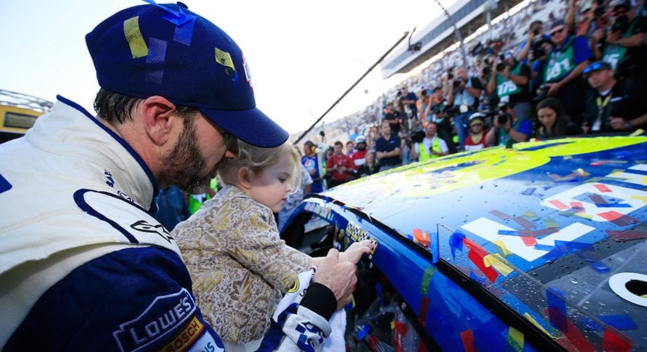 Jimmie Johnson, with help from daughter Lydia, puts the winner's sticker on his No. 48 car after winning at Martinsville in 2016.