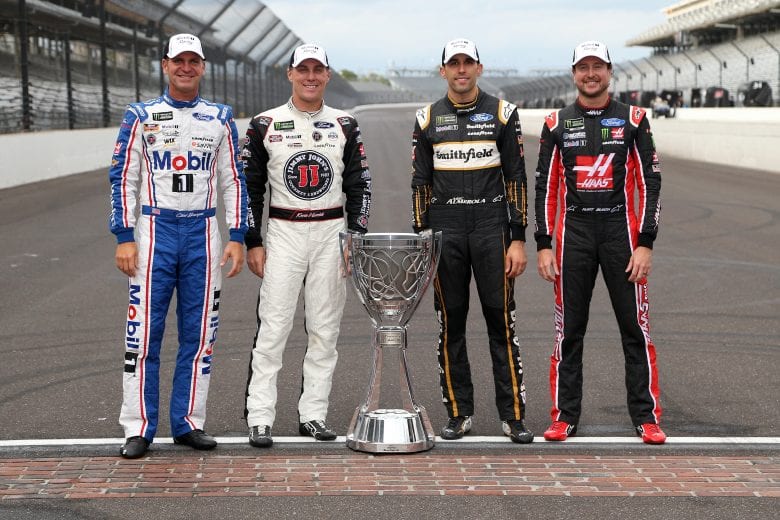 INDIANAPOLIS, IN - SEPTEMBER 10:  Clint Bowyer, driver of the #14 Mobil 1/Rush Truck Centers Ford, Kevin Harvick, driver of the #4 Jimmy John's New 9-Grain Wheat Sub Ford, Aric Almirola, driver of the #10 Smithfield Ford, Kurt Busch, driver of the #41 Haas Automation/Monster Energy Ford,   pose for a photo with the Monster Energy NASCAR Cup Series trophy after making the playoffs following the Monster Energy NASCAR Cup Series Big Machine Vodka 400 at the Brickyard at Indianapolis Motor Speedway on September 10, 2018 in Indianapolis, Indiana.  (Photo by Brian Lawdermilk/Getty Images) | Getty Images