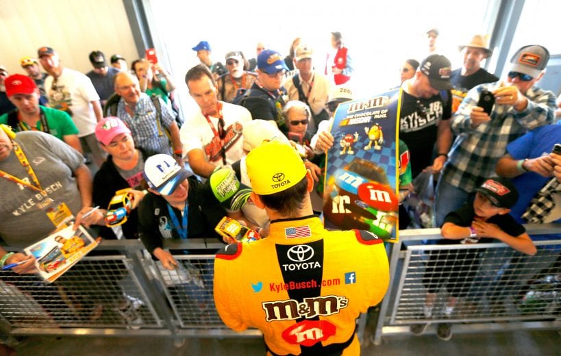 PHOENIX, AZ - NOVEMBER 09:  Kyle Busch, driver of the #18 M&M's Toyota, signs autographs for fans in the garage area during practice for the Monster Energy NASCAR Cup Series Can-Am 500 at ISM Raceway on November 9, 2018 in Phoenix, Arizona.  (Photo by Jonathan Ferrey/Getty Images) | Getty Images