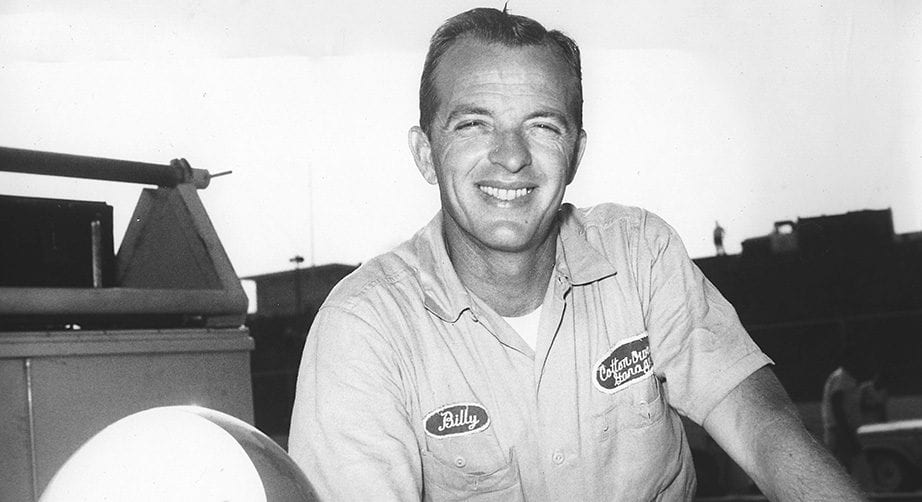 Billy Wade poses for a photo next to his race car.