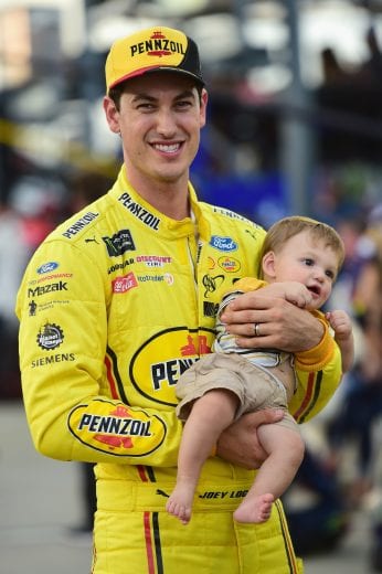 Joey Logano holds his son, Hudson, on the grid at Darlington Raceway.
