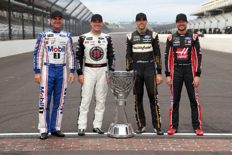 INDIANAPOLIS, IN - SEPTEMBER 10:  Clint Bowyer, driver of the #14 Mobil 1/Rush Truck Centers Ford, Kevin Harvick, driver of the #4 Jimmy John's New 9-Grain Wheat Sub Ford, Aric Almirola, driver of the #10 Smithfield Ford, Kurt Busch, driver of the #41 Haas Automation/Monster Energy Ford,   pose for a photo with the Monster Energy NASCAR Cup Series trophy after making the playoffs following the Monster Energy NASCAR Cup Series Big Machine Vodka 400 at the Brickyard at Indianapolis Motor Speedway on September 10, 2018 in Indianapolis, Indiana.  (Photo by Brian Lawdermilk/Getty Images) | Getty Images