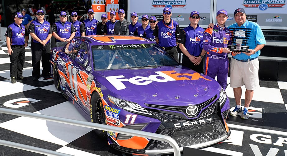 Denny Hamlin poses with the No. 11 crew after qualifying on the front row for the 2018 Daytona 500.