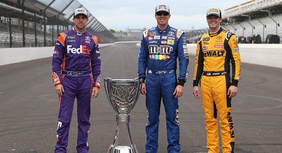 Denny Hamlin, Kyle Busch and Erik Jones pose with the Monster Energy Series championship trophy at Indianapolis.