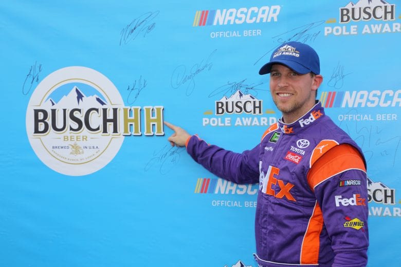 Denny Hamlin holds up the Busch Pole Award flag.