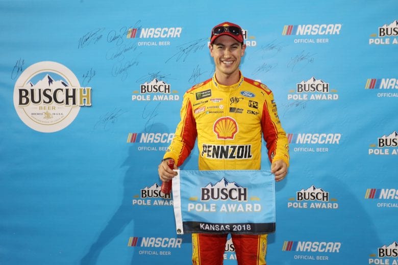 Joey Logano holds up the Busch Pole Award flag.