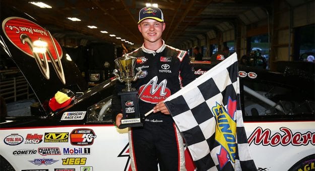 Tyler Ankrum poses with the checkered flag