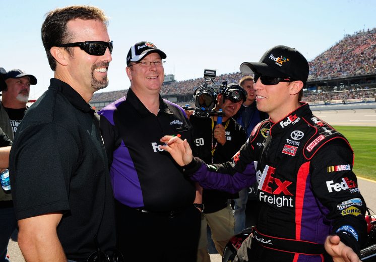 TALLADEGA, AL - OCTOBER 31: Denny Hamlin (R), driver of the #11 FedEx Freight Toyota, talks with car owner J.D. Gibbs (L) and crew chief Mike Ford (C) during the NASCAR Sprint Cup Series AMP Energy Juice 500 at Talladega Superspeedway on October 31, 2010 in Talladega, Alabama. (Photo by Rusty Jarrett/Getty Images for NASCAR) | Getty Images