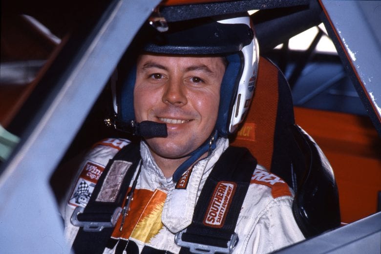 Alan Kulwicki looks on in his race car.