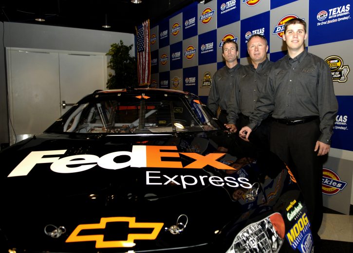 FORT WORTH, TX - NOVEMBER 6: Denny Hamlin (Front) with (L-R) team president J.D. Gibbs and vice president Jimmy Makar, announce Hamlin as the driver of the #11 FedEx Chevrolet, during a press conference at the NASCAR Nextel Cup Series Dickies 500 on November 6, 2005 at the Texas Motor Speedway in Fort Worth, Texas. (Photo by Rusty Jarrett/Getty Images) | Getty Images