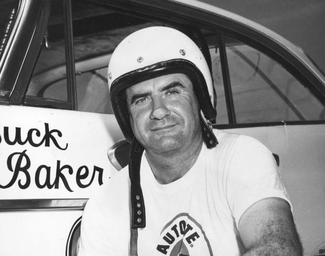 Buck Baker poses next to his race car.