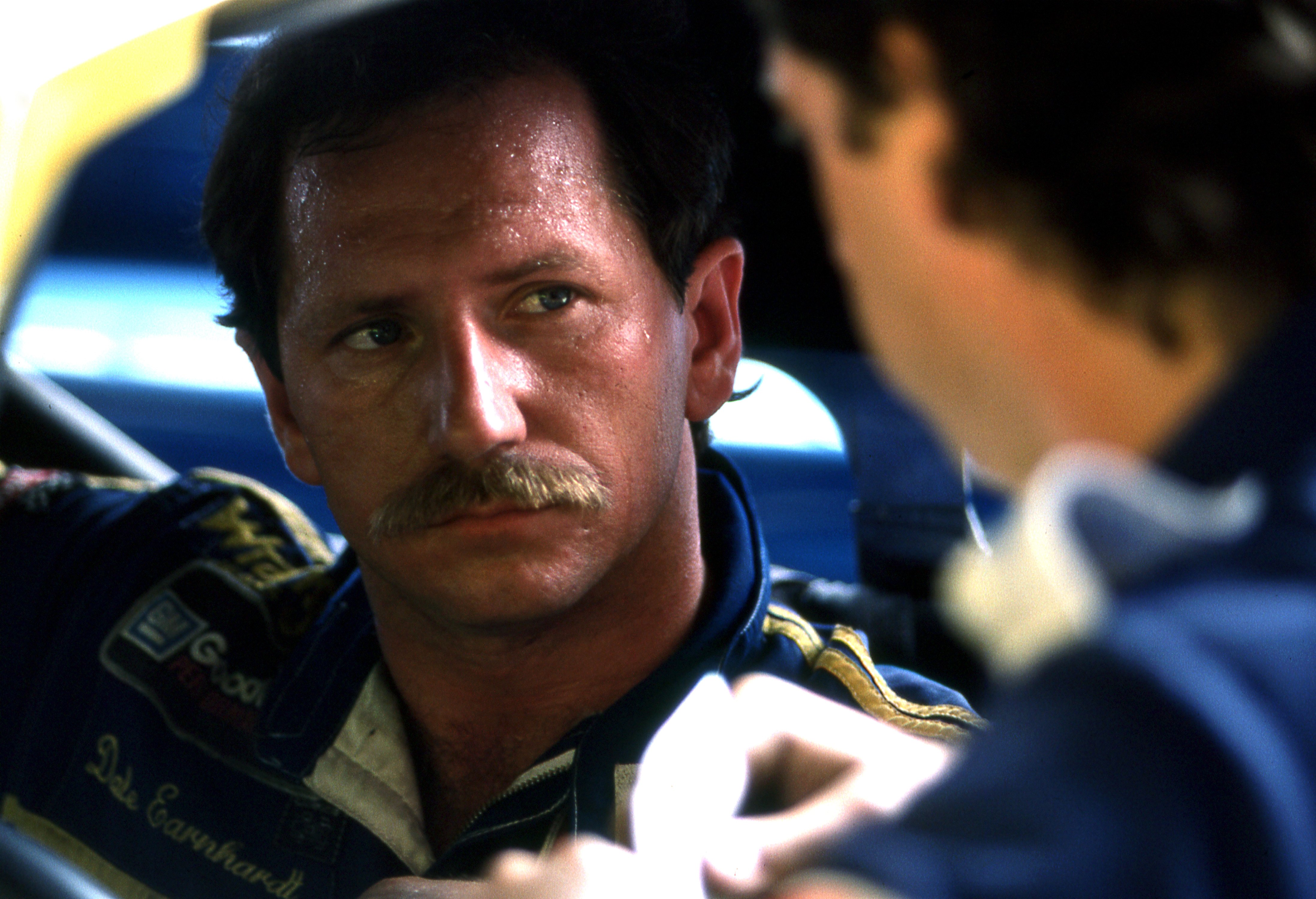 DAYTONA BEACH, FL - JULY 3:  Dale Earnhardt sweats in the summer heat while talking with crew chief Kirk Shelmedine during practice for the Firecracker 400 race on July 3, 1986 at the Daytona International Speedway in Daytona Beach, Florida.  (Photo by Dozier Mobley/Getty Images)