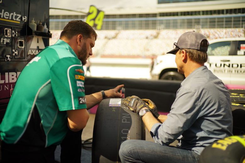 Concord, NC - (L to R) Landon Walker uses a gauge to show Host Phil Keoghan how to measure the tread depth of a tire. (National Geographic/Alex Mandiola)