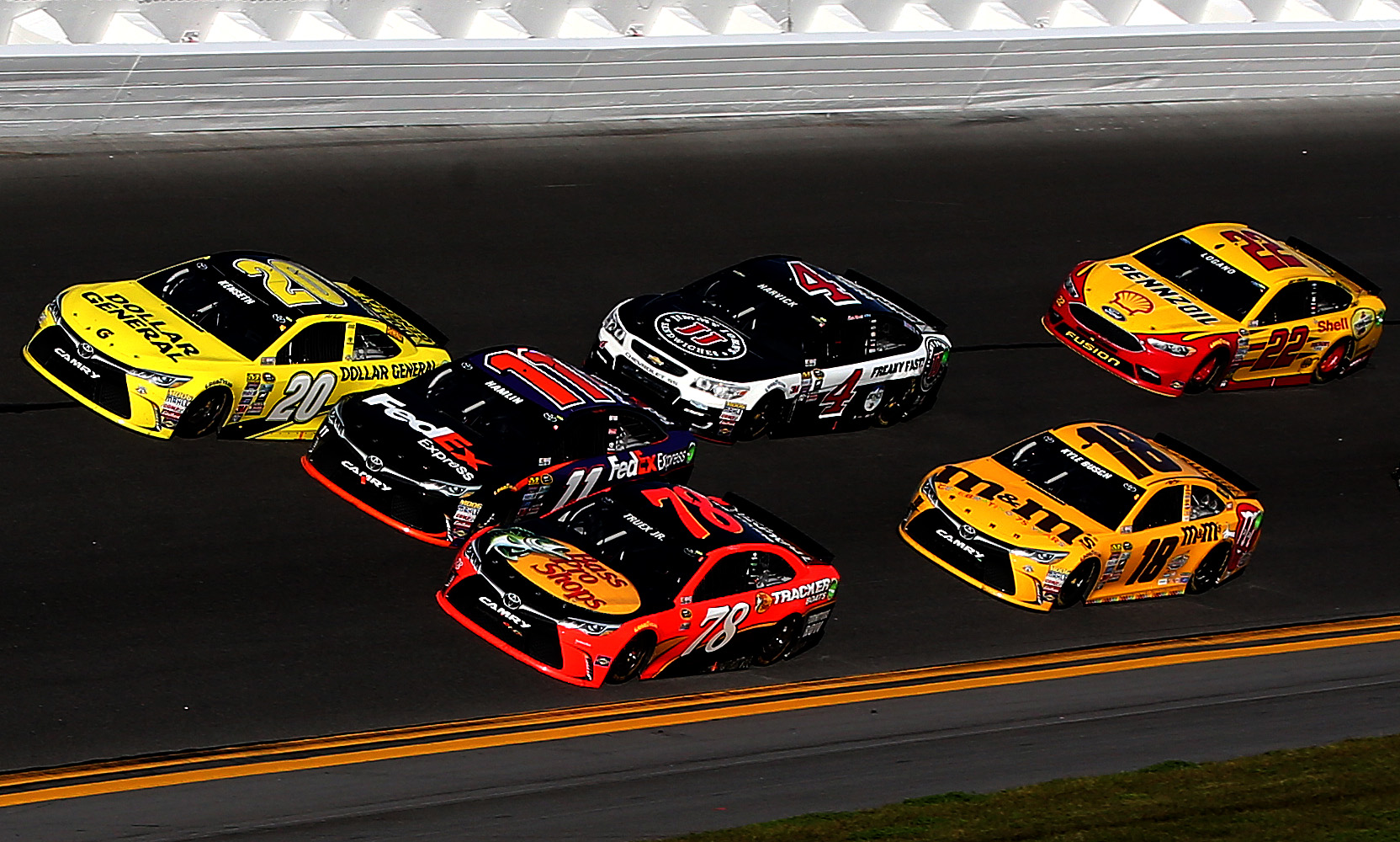 DAYTONA BEACH, FL - FEBRUARY 21: Matt Kenseth, driver of the #20 Dollar General Toyota, races Denny Hamlin, driver of the #11 FedEx Express Toyota, and Martin Truex Jr., driver of the #78 Bass Pro Shops/Tracker Boats Toyota, ahead of the field during the NASCAR Sprint Cup Series DAYTONA 500 at Daytona International Speedway on February 21, 2016 in Daytona Beach, Florida. (Photo by Sean Gardner/Getty Images) | Getty Images