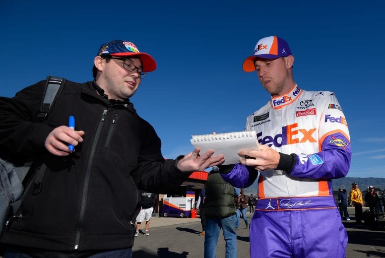 FONTANA, CA - MARCH 15:  Denny Hamlin, driver of the #11 FedEx Express Toyota, signs autographs for fans during practice for the Monster Energy NASCAR Cup Series Auto Club 400 at Auto Club Speedway on March 15, 2019 in Fontana, California.  (Photo by Robert Laberge/Getty Images) | Getty Images