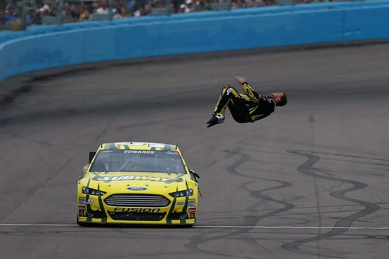 AVONDALE, AZ - MARCH 03:  Carl Edwards, driver of the #99 Subway Ford, performs a back flip to celebrate after winning the NASCAR Sprint Cup Series Subway Fresh Fit 500 at Phoenix International Raceway on March 3, 2013 in Avondale, Arizona.  (Photo by Jonathan Ferrey/Getty Images) | Getty Images