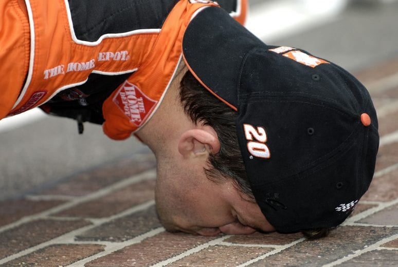 INDIANAPOLIS - AUGUST 7:  Tony Stewart, driver of the #20 Home Depot Chevrolet, kisses the bricks after winning the NASCAR Nextel Cup Series Allstate 400 on August 7, 2005 at the Indianapolis Motor Speedway in Indianapolis, Indiana.  (Photo by Rusty Jarrett/Getty Images) | Getty Images