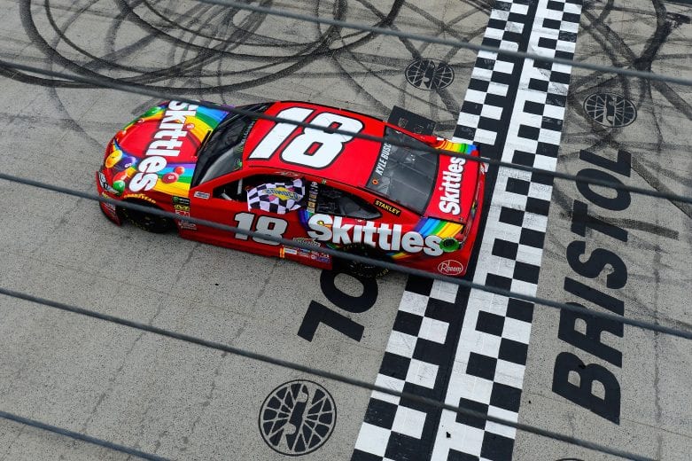 BRISTOL, TN - APRIL 16: Kyle Busch, driver of the #18 Skittles Toyota, celebrates with the checkered flag after winning the rain delayed Monster Energy NASCAR Cup Series Food City 500 at Bristol Motor Speedway on April 16, 2018 in Bristol, Tennessee. (Photo by Robert Laberge/Getty Images) | Getty Images