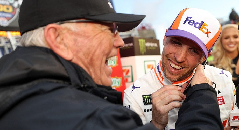 Denny Hamlin takes a phone call in Victory Lane at Texas courtesy of team owner Joe Gibbs.