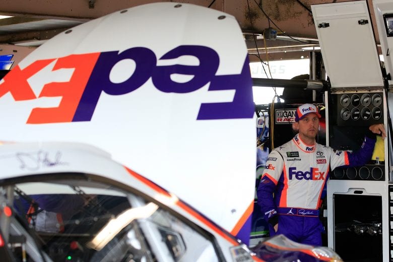 DOVER, DE - MAY 03: Denny Hamlin, driver of the #11 FedEx Office Toyota, stands in the garage during practice for the Monster Energy NASCAR Cup Series Gander RV 400 at Dover International Speedway on May 3, 2019 in Dover, Delaware. (Photo by Chris Trotman/Getty Images) | Getty Images