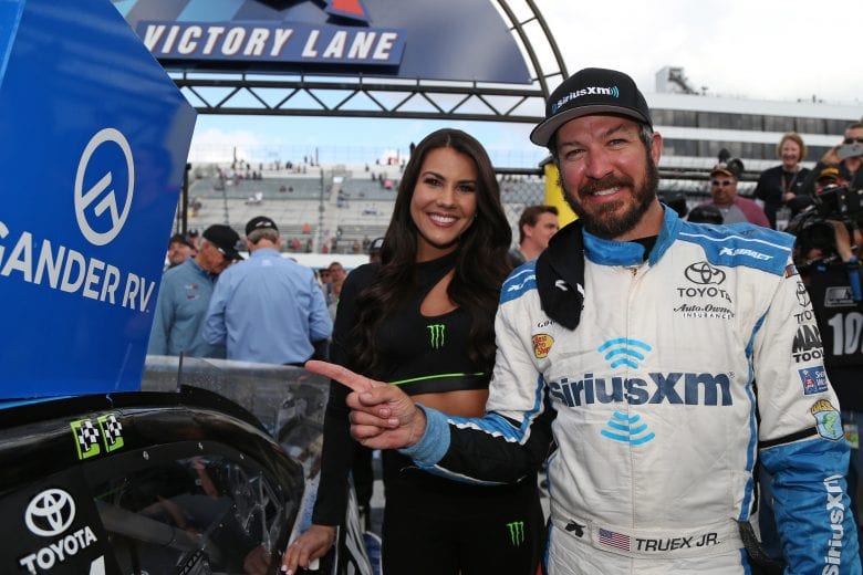 Martin Truex Jr. puts the winner's sticker on the No. 19 in Victory Lane at Dover.