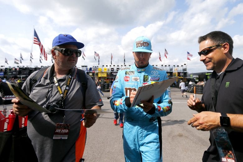 LONG POND, PENNSYLVANIA - MAY 31: Kyle Busch, driver of the #18 M&M's Hazelnut Toyota, signs an autograph during practice for the Monster Energy NASCAR Cup Series Pocono 400 at Pocono Raceway on May 31, 2019 in Long Pond, Pennsylvania. (Photo by Jonathan Ferrey/Getty Images) | Getty Images