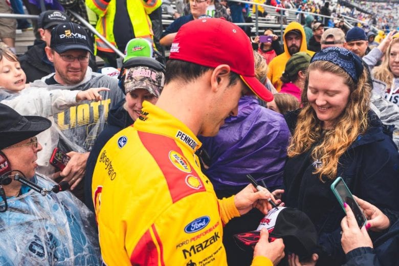 Joey Logano joins the fans in the stands at Dover.