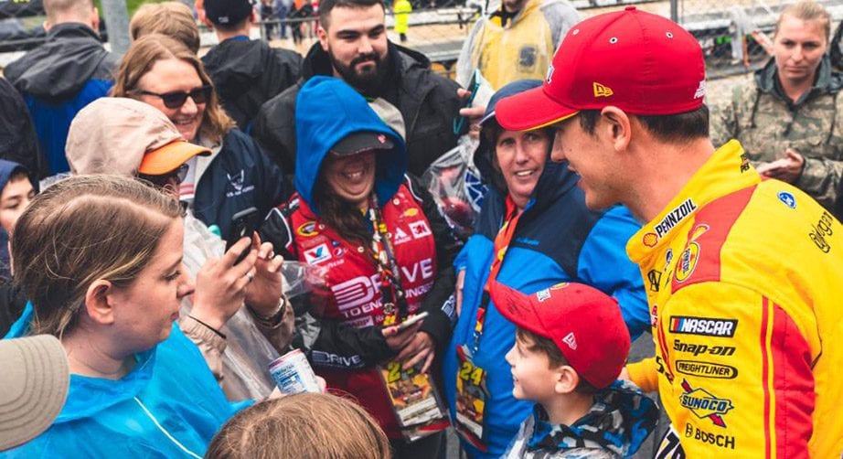 Joey Logano joins the fans in the stands at Dover.