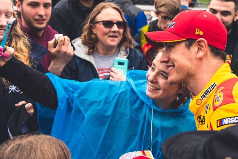 Joey Logano joins the fans in the stands at Dover.