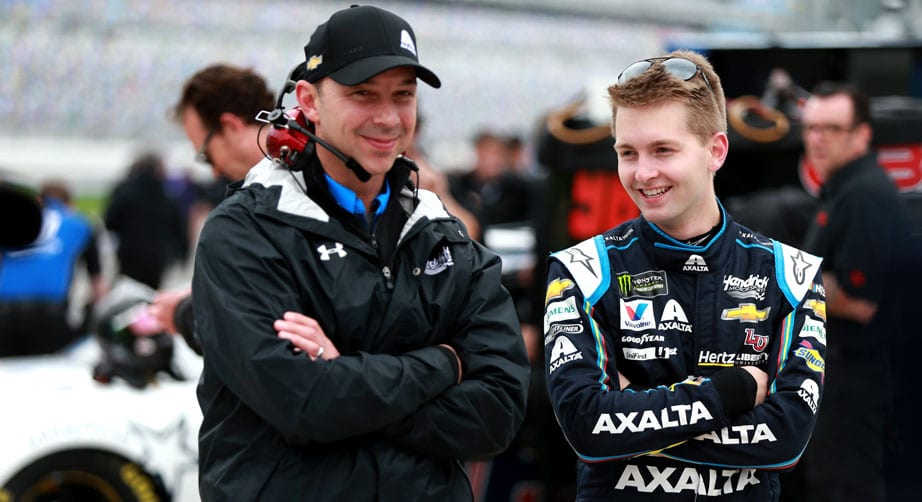 Chad Knaus and William Byron speak in the garage area.