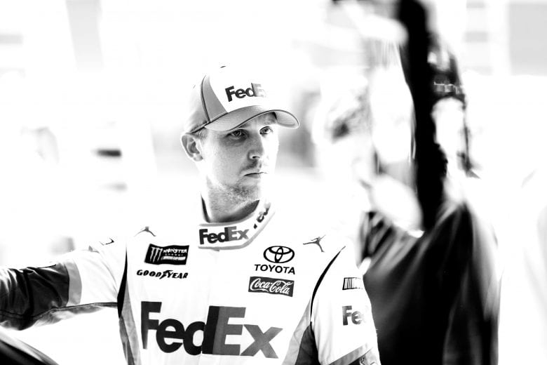 KANSAS CITY, KS - MAY 10: (EDITOR'S NOTE: Image was converted to black and white.) Denny Hamlin, driver of the #11 FedEx Freight Toyota, stands in the garage during practice for the Monster Energy NASCAR Cup Series Digital Ally 400 at Kansas Speedway on May 10, 2019 in Kansas City, Kansas. (Photo by Jonathan Ferrey/Getty Images) | Getty Images