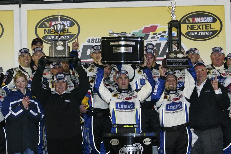 DAYTONA BEACH, FL - FEBRUARY 19:  Team owner Rick Hendrick, Jimmie Johnson, driver of the #48 Lowe's Chevrolet, and Darian Grubb hold aloft the winners trophies after victory in  the NASCAR Nextel Cup Series Daytona 500 on February 19, 2006 at the Daytona International Speedway in Daytona Beach, Florida.  (Photo by Gavin Lawrence/Getty Images) | Getty Images