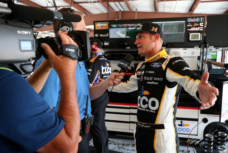 JOLIET, ILLINOIS - JUNE 29: Clint Bowyer, driver of the #14 Toco Warranty Ford, is interviewed in the garage during practice for the Monster Energy NASCAR Cup Series Camping World 400 at Chicagoland Speedway on June 29, 2019 in Joliet, Illinois. (Photo by Jonathan Daniel/Getty Images) | Getty Images