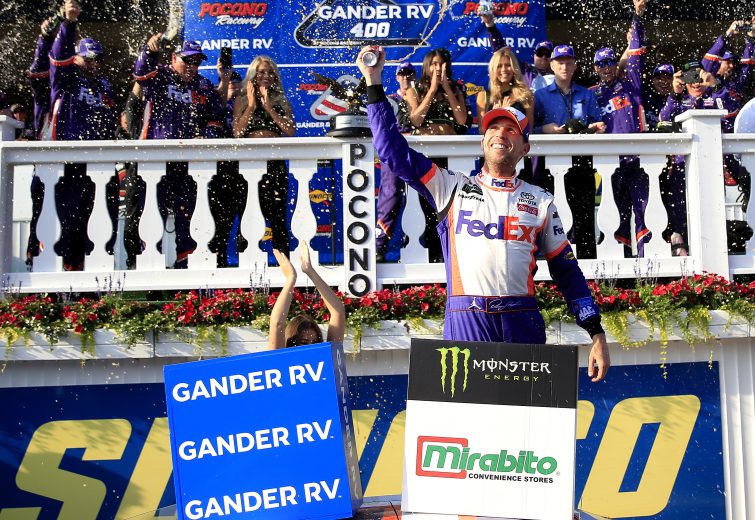 LONG POND, PENNSYLVANIA - JULY 28: Denny Hamlin, driver of the #11 FedEx Ground Toyota, clebrates in victory lane after winning the Monster Energy NASCAR Cup Series Gander RV 400 at Pocono Raceway on July 28, 2019 in Long Pond, Pennsylvania. (Photo by Chris Trotman/Getty Images) | Getty Images