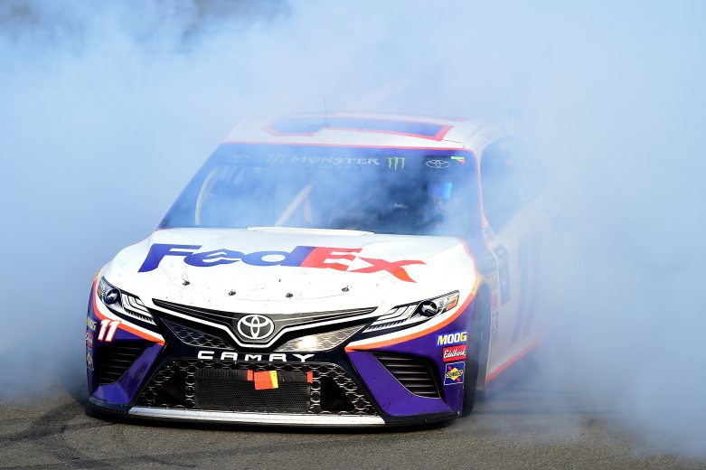 LONG POND, PENNSYLVANIA - JULY 28: Denny Hamlin, driver of the #11 FedEx Ground Toyota, celebrates with a burnout after winning the Monster Energy NASCAR Cup Series Gander RV 400 at Pocono Raceway on July 28, 2019 in Long Pond, Pennsylvania. (Photo by Jared C. Tilton/Getty Images) | Getty Images