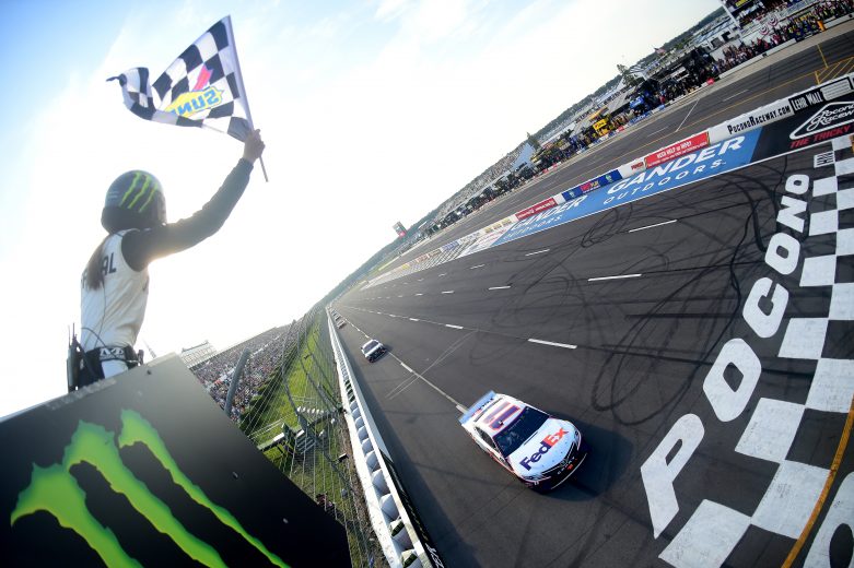 LONG POND, PENNSYLVANIA - JULY 28: Denny Hamlin, driver of the #11 FedEx Ground Toyota, takes the checkered flag to win the Monster Energy NASCAR Cup Series Gander RV 400 at Pocono Raceway on July 28, 2019 in Long Pond, Pennsylvania. (Photo by Jared C. Tilton/Getty Images) | Getty Images