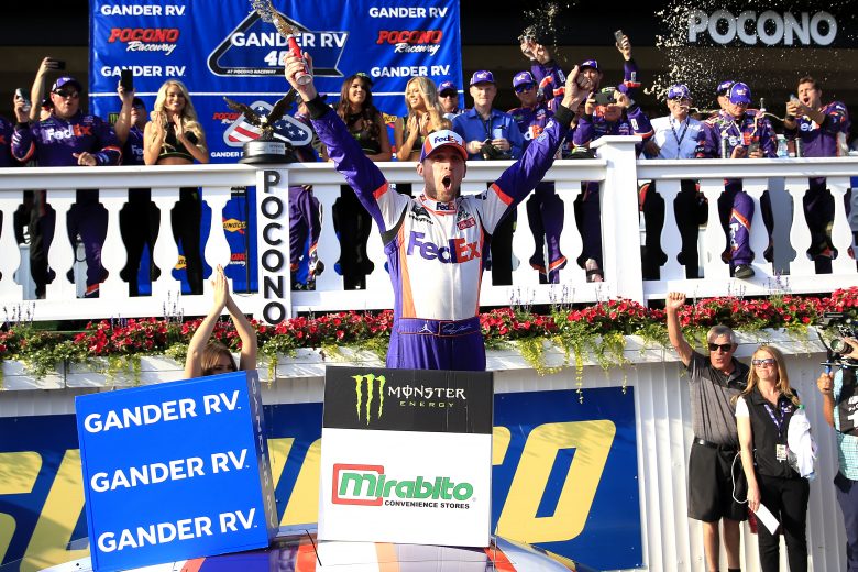 LONG POND, PENNSYLVANIA - JULY 28: Denny Hamlin, driver of the #11 FedEx Ground Toyota, clebrates in victory lane after winning the Monster Energy NASCAR Cup Series Gander RV 400 at Pocono Raceway on July 28, 2019 in Long Pond, Pennsylvania. (Photo by Chris Trotman/Getty Images) | Getty Images
