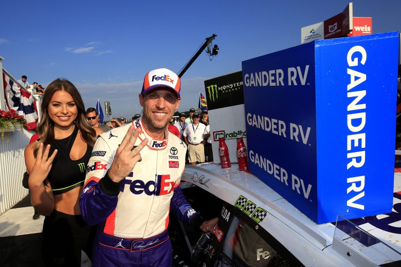 LONG POND, PENNSYLVANIA - JULY 28: Denny Hamlin, driver of the #11 FedEx Ground Toyota, poses with the winner's decal on his car in Victory Lane after winning the Monster Energy NASCAR Cup Series Gander RV 400 at Pocono Raceway on July 28, 2019 in Long Pond, Pennsylvania. (Photo by Chris Trotman/Getty Images) | Getty Images