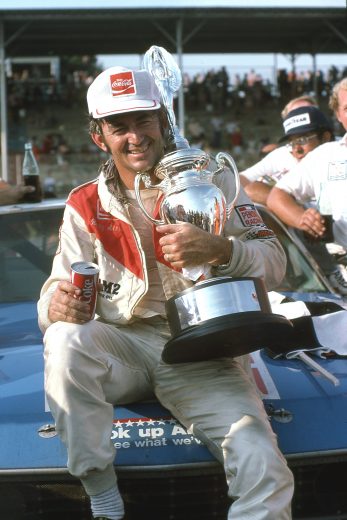 DARLINGTON, SC - SEPTEMBER 1: Driver Bobby Allison poses with trophy while drinking a Coca-Cola on September 1, 1975 after winning the Southern 500 race at Darlington Raceway in Darlington, South Carolina. Photo by Dozier Mobley/Getty Images)