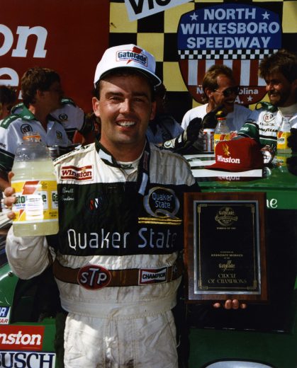 NORTH WILKESBORO, NC - APRIL 22: Brett Bodine, driver of the #26 Quaker State Buick, celebrates joining the Gatorade Circle of Champions after winning the NASCAR Winston Cup Series First Union 400 on April 12, 1990 at the North Wilkesboro Speedway in North Wilkesboro, North Carolina.