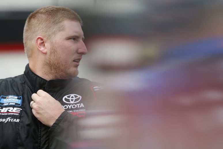 BRISTOL, TENNESSEE - AUGUST 15: Austin Hill, driver of the #16 Toyota Tsusho Toyota, stands in the garage during practice for the NASCAR Gander Outdoor Truck Series UNOH 200 presented by Ohio Logistics at Bristol Motor Speedway on August 15, 2019 in Bristol, Tennessee. (Photo by Brian Lawdermilk/Getty Images) | Getty Images