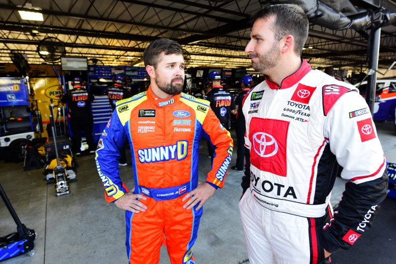 DARLINGTON, SOUTH CAROLINA - AUGUST 30: Ricky Stenhouse Jr., driver of the #17 Dog's Most Wanted Ford, and Matt DiBenedetto, driver of the #95 IMSA GTO Throwback Toyota, stand in the garage area during practice for the Monster Energy NASCAR Cup Series Bojangles' Southern 500 at Darlington Raceway on August 30, 2019 in Darlington, South Carolina. (Photo by Jared C. Tilton/Getty Images) | Getty Images