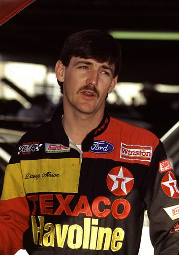 1991: Davey Allison stands in the garage before Ricky Rudd wins the race at Infineon in 1991, but the victory is taken away after NASCAR charges Rudd with roughing up Allison with one lap to go. It is an unprecedented move in NASCAR competition. Later that year, at the NASCAR Awards Banquet in New York, Allison needles Rudd by presenting him with a crying towel. (Photo by ISC Archives/CQ-Roll Call Group via Getty Images)