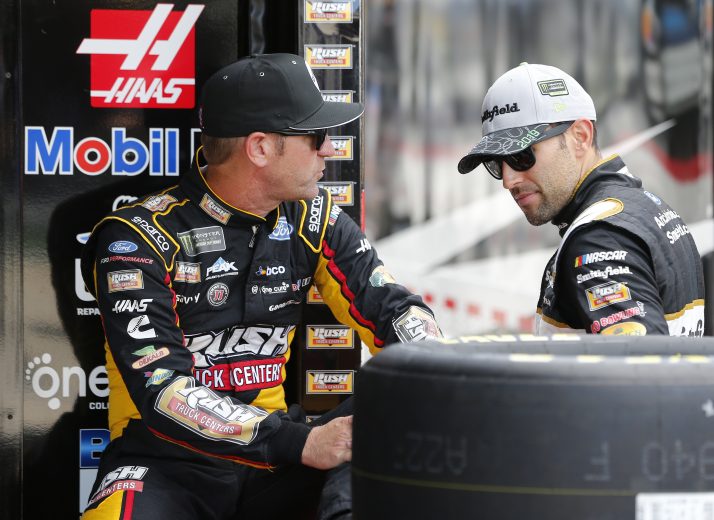 CHARLOTTE, NORTH CAROLINA - SEPTEMBER 27: Aric Almirola, driver of the #10 Smithfield Ford, and Clint Bowyer, driver of the #14 Rush/Cummins Ford, speak in the garage area during practice for the Monster Energy NASCAR Cup Series Bank of America ROVAL 400 at Charlotte Motor Speedway on September 27, 2019 in Charlotte, North Carolina. (Photo by Brian Lawdermilk/Getty Images) | Getty Images