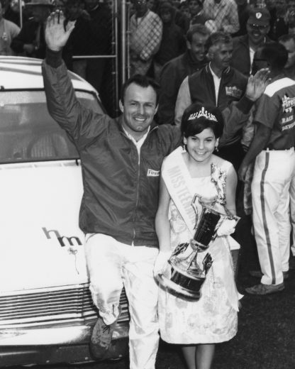 DAYTONA BEACH, FL - FEBRUARY 14: Fred Lorenzen driver of the #28 LaFayette Ford stands in Victory Lane with his trophy and the trophy girl after winning the 1965 Daytona 500 on February 14, 1965 at the Daytona International Speedway in Daytona Beach, Florida. (Photo by ISC Archives/CQ-Roll Call Group via Getty Images)