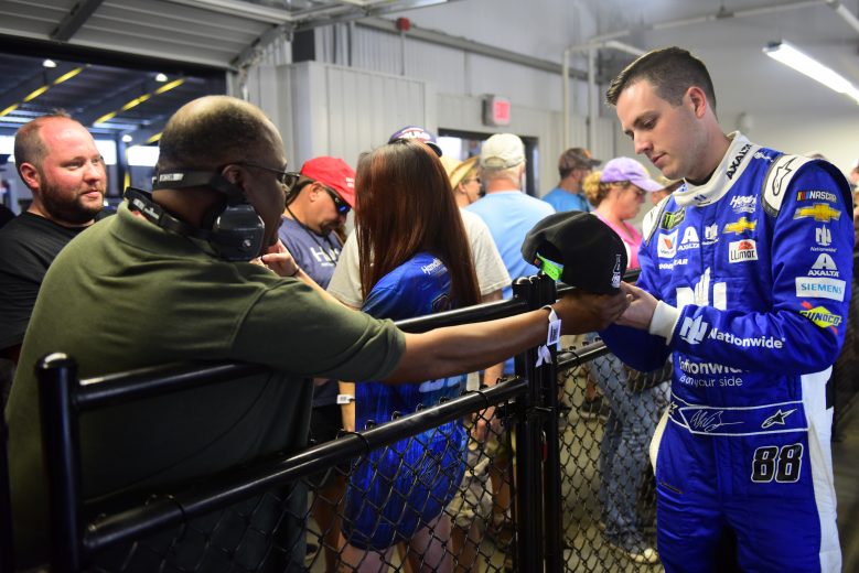 TALLADEGA, ALABAMA - OCTOBER 11: Alex Bowman, driver of the #88 Nationwide/Amazon Echo Auto Chevrolet, signs autographs for fans in the garage area during practice for the Monster Energy NASCAR Cup Series 1000Bulbs.com 500 at Talladega Superspeedway on October 11, 2019 in Talladega, Alabama. (Photo by Jared C. Tilton/Getty Images) | Getty Images